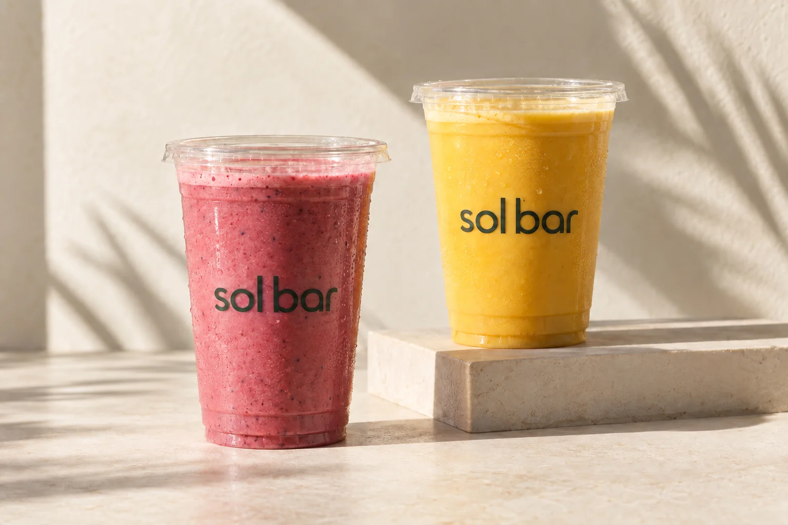 Pink and yellow Sol Bar smoothies in clear cups